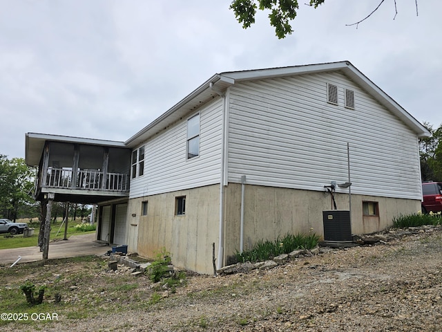 979 S Matherly Rd, Protem, MO 65733 - view of side of home with driveway, a sunroom, central AC unit, and an attached garage