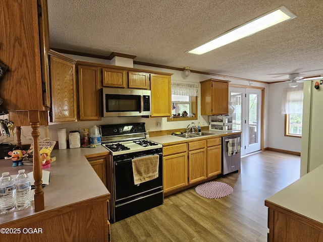 979 S Matherly Rd, Protem, MO 65733 - kitchen featuring stainless steel appliances, a sink, light wood finished floors, a textured ceiling, and light countertops