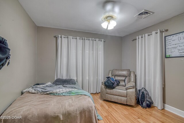 615 E 15th St, Joplin, MO 64801 - bedroom featuring wood finished floors, visible vents, and baseboards