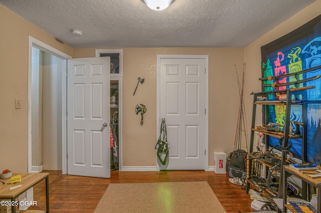 615 E 15th St, Joplin, MO 64801 - foyer entrance with a textured wall, a textured ceiling, baseboards, and wood finished floors