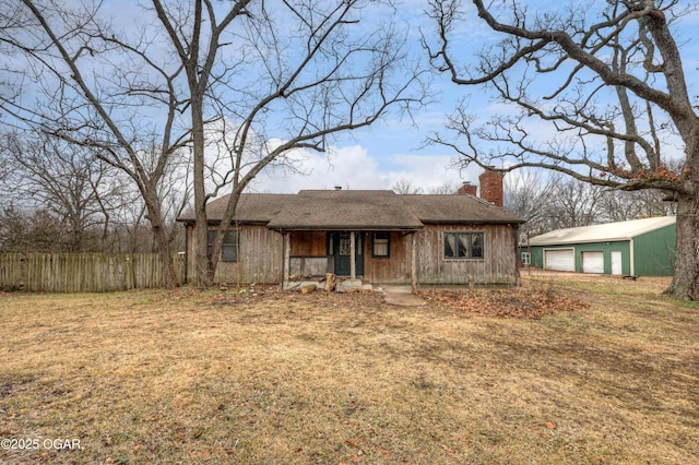 single story home with an outbuilding, a garage, and a front lawn