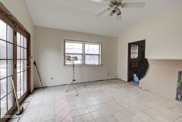 tiled empty room featuring lofted ceiling and ceiling fan