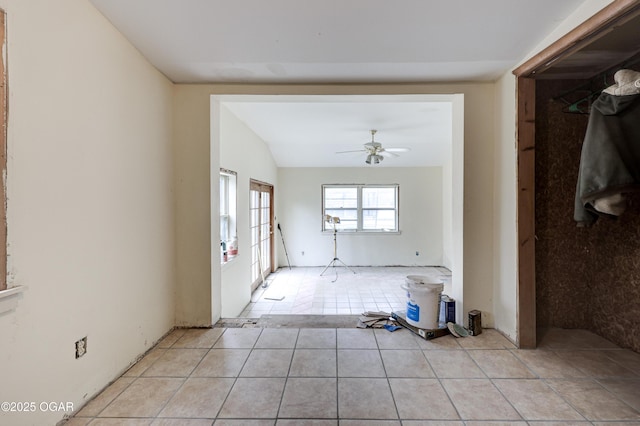 interior space featuring lofted ceiling, light tile patterned floors, and ceiling fan