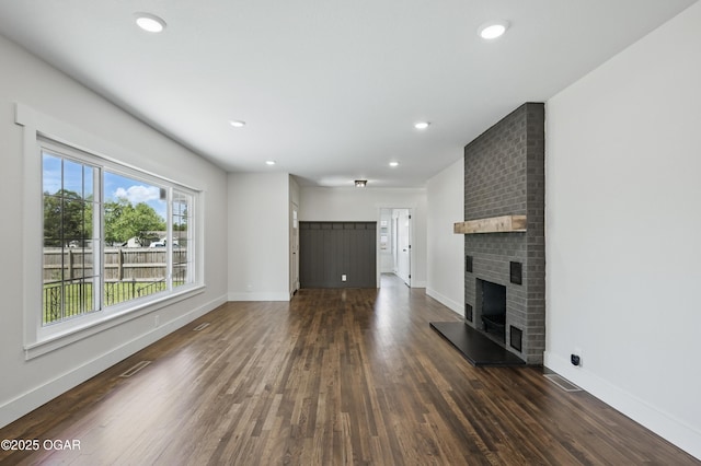 540 E 4th St, Baxter Springs, KS 66713 - unfurnished living room featuring dark wood-style flooring, baseboards, a fireplace, and recessed lighting