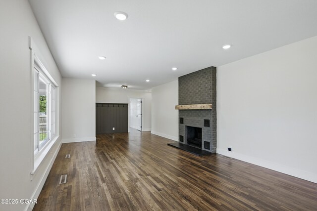 540 E 4th St, Baxter Springs, KS 66713 - unfurnished living room with dark wood-style flooring, a fireplace, baseboards, and recessed lighting