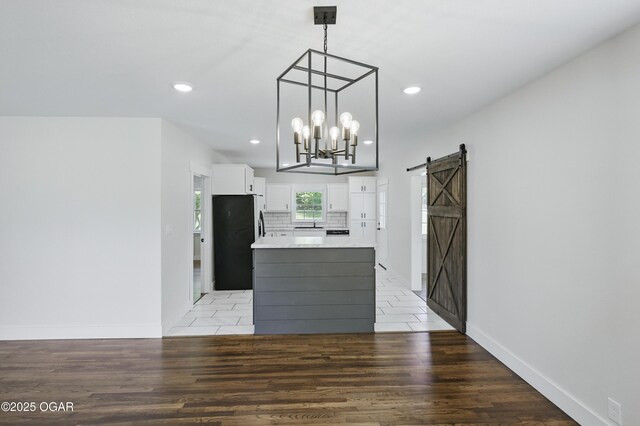 540 E 4th St, Baxter Springs, KS 66713 - kitchen with stainless steel refrigerator, a barn door, white cabinetry, a chandelier, and a center island
