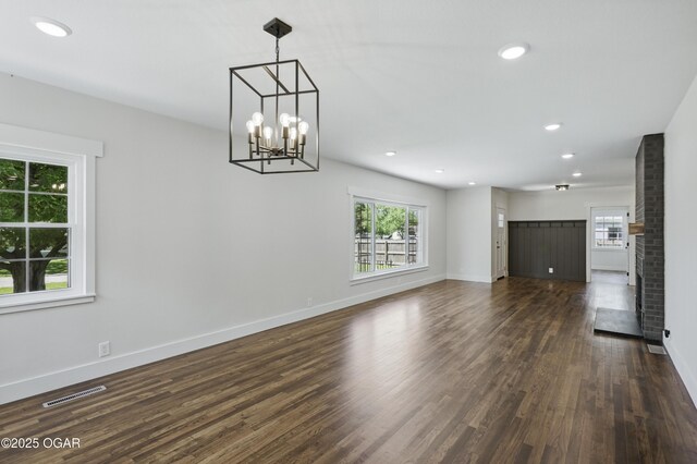 540 E 4th St, Baxter Springs, KS 66713 - unfurnished living room featuring dark wood-type flooring, baseboards, recessed lighting, and a chandelier