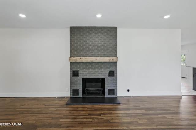 540 E 4th St, Baxter Springs, KS 66713 - unfurnished living room with a brick fireplace, wood finished floors, recessed lighting, and baseboards