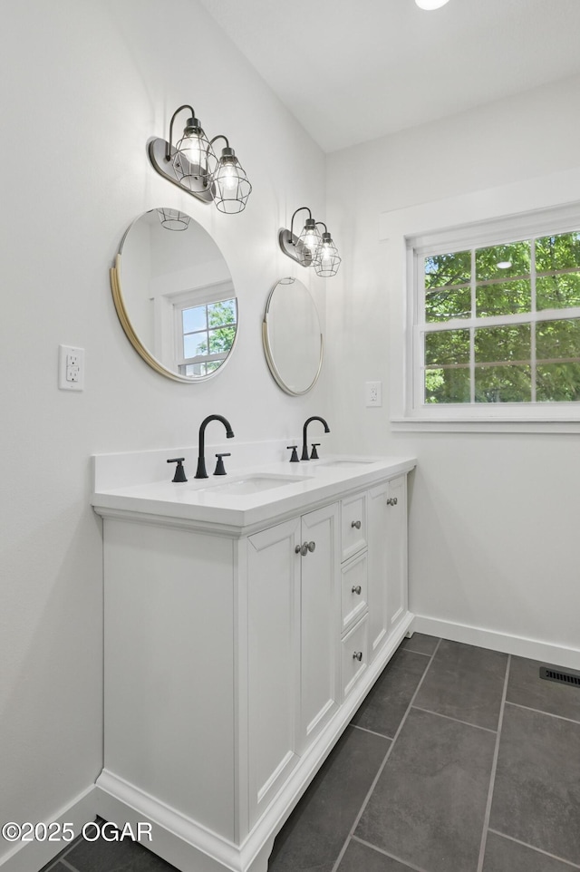 540 E 4th St, Baxter Springs, KS 66713 - bathroom featuring healthy amount of natural light, double vanity, baseboards, and tile patterned flooring