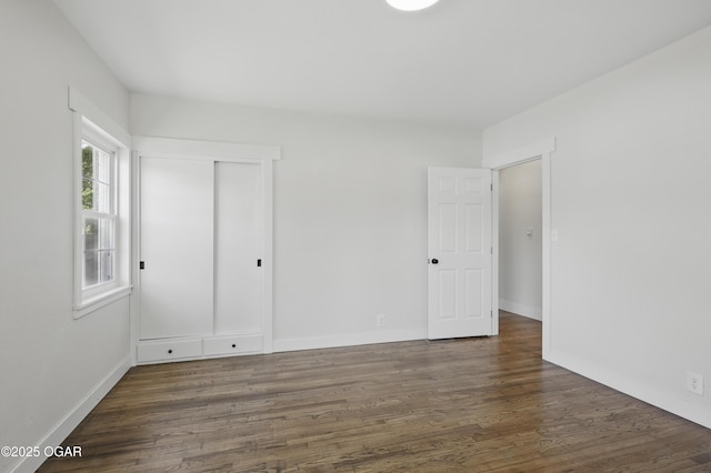 540 E 4th St, Baxter Springs, KS 66713 - unfurnished bedroom with wood finished floors, baseboards, and a closet