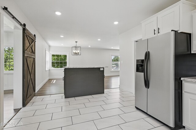 540 E 4th St, Baxter Springs, KS 66713 - kitchen featuring stainless steel fridge with ice dispenser, a barn door, plenty of natural light, white cabinets, and recessed lighting