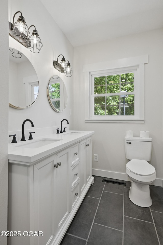 540 E 4th St, Baxter Springs, KS 66713 - full bath featuring tile patterned flooring, toilet, double vanity, and baseboards