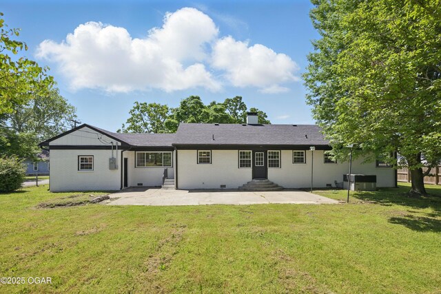 540 E 4th St, Baxter Springs, KS 66713 - rear view of property with entry steps, a patio, a chimney, and a lawn