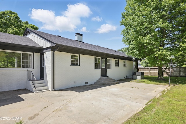 540 E 4th St, Baxter Springs, KS 66713 - rear view of house featuring a patio area, a chimney, brick siding, and roof with shingles