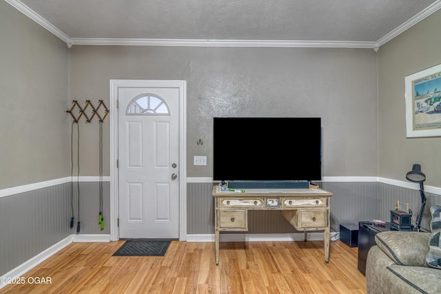 foyer featuring hardwood / wood-style flooring, crown molding, and a textured ceiling