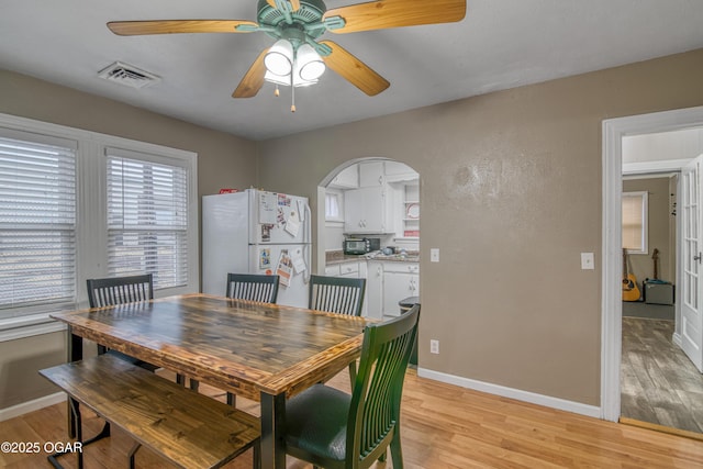 dining area with ceiling fan and light wood-type flooring