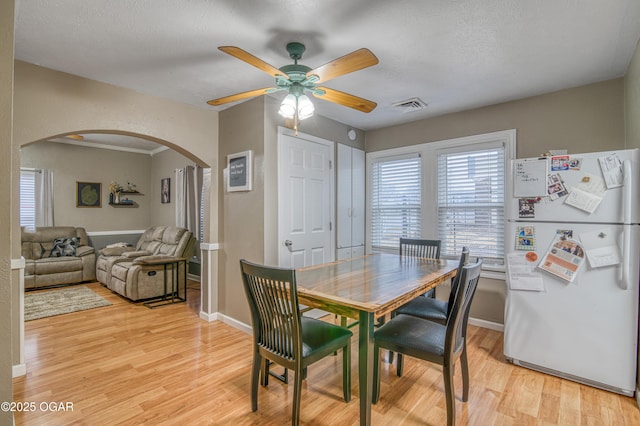 dining space featuring ceiling fan, light hardwood / wood-style flooring, and a textured ceiling