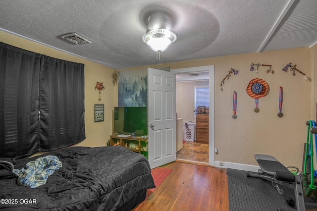 bedroom featuring wood-type flooring and a textured ceiling