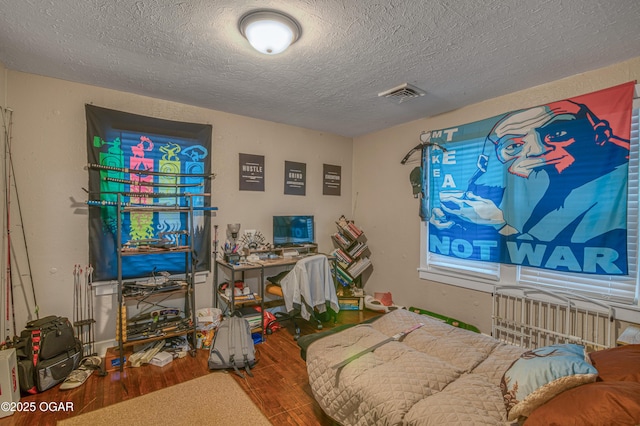 bedroom with hardwood / wood-style flooring and a textured ceiling