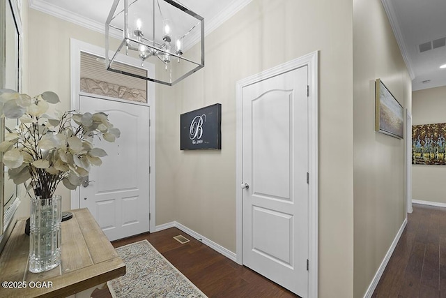 foyer featuring crown molding, dark hardwood / wood-style flooring, and an inviting chandelier