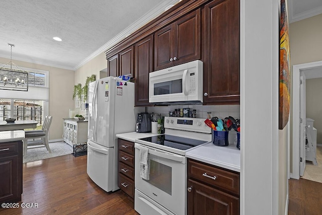 kitchen with crown molding, white appliances, decorative light fixtures, and dark wood-type flooring