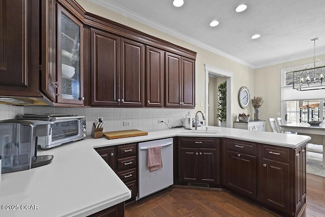 kitchen with sink, decorative light fixtures, ornamental molding, dishwasher, and kitchen peninsula