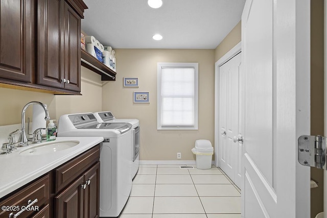 washroom with separate washer and dryer, sink, cabinets, and light tile patterned flooring