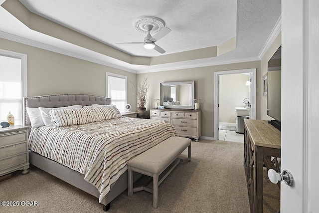 carpeted bedroom with ceiling fan, ornamental molding, a tray ceiling, and a textured ceiling