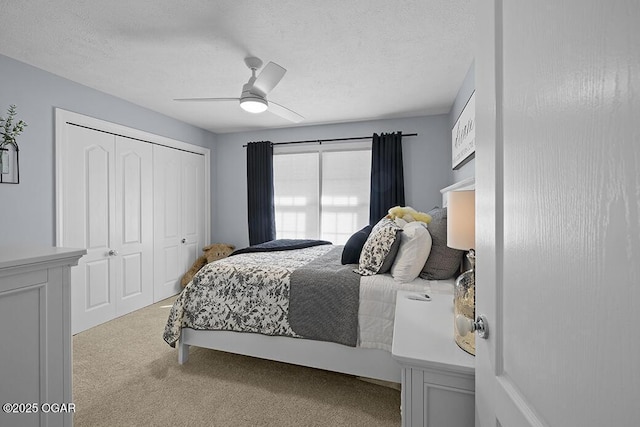 carpeted bedroom featuring ceiling fan, a closet, and a textured ceiling