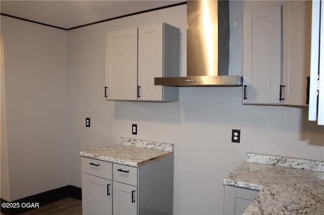 kitchen featuring white cabinetry, light stone countertops, dark hardwood / wood-style floors, and wall chimney exhaust hood