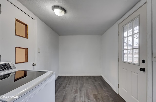 clothes washing area with washer / dryer, a textured ceiling, and hardwood / wood-style flooring