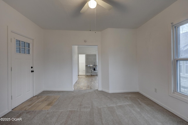 carpeted spare room with ceiling fan