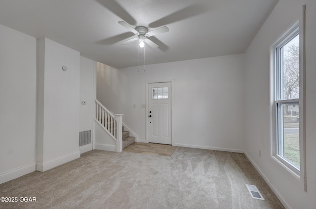 interior space featuring light carpet and ceiling fan