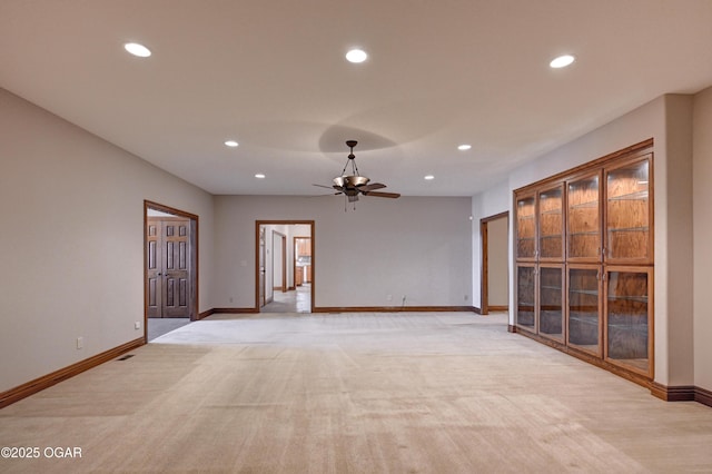 unfurnished living room featuring light colored carpet and ceiling fan