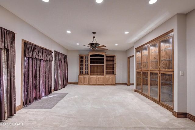 unfurnished living room featuring ceiling fan and light colored carpet