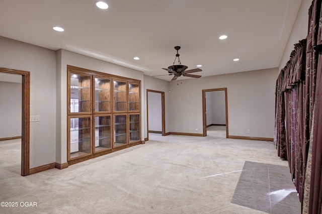 unfurnished room with ceiling fan and light carpet