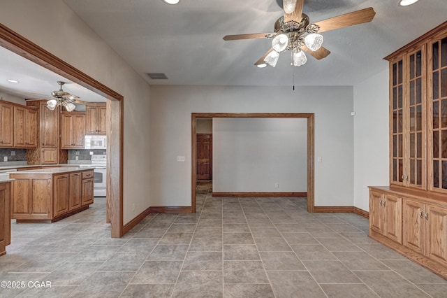 kitchen with range with electric cooktop, ceiling fan, light tile patterned flooring, and decorative backsplash