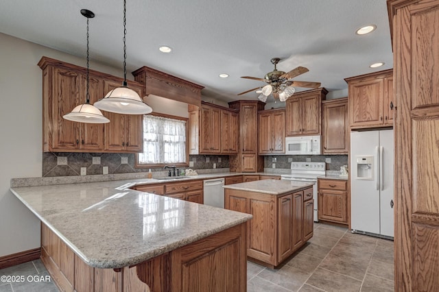 kitchen featuring sink, decorative light fixtures, a center island, kitchen peninsula, and white appliances