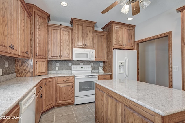 kitchen featuring light stone counters, white appliances, light tile patterned floors, ceiling fan, and backsplash