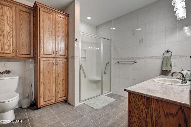 bathroom featuring toilet, an enclosed shower, tile walls, vanity, and tile patterned flooring