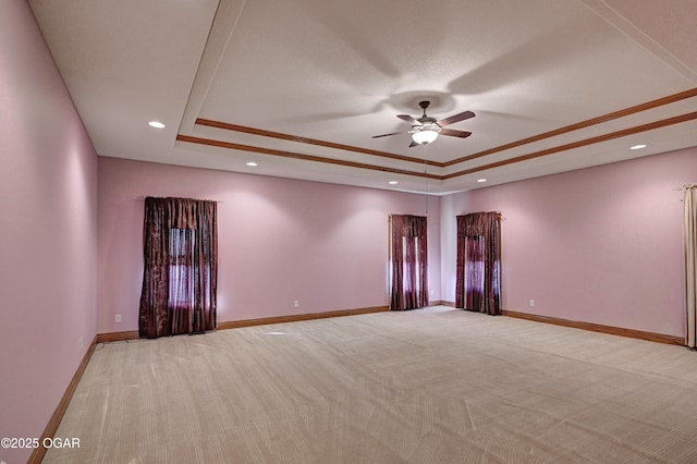 spare room with light carpet, ceiling fan, and a tray ceiling