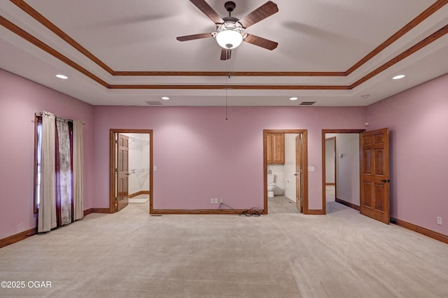 unfurnished bedroom featuring light carpet, a tray ceiling, and ornamental molding