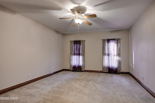 carpeted empty room featuring ceiling fan and a textured ceiling