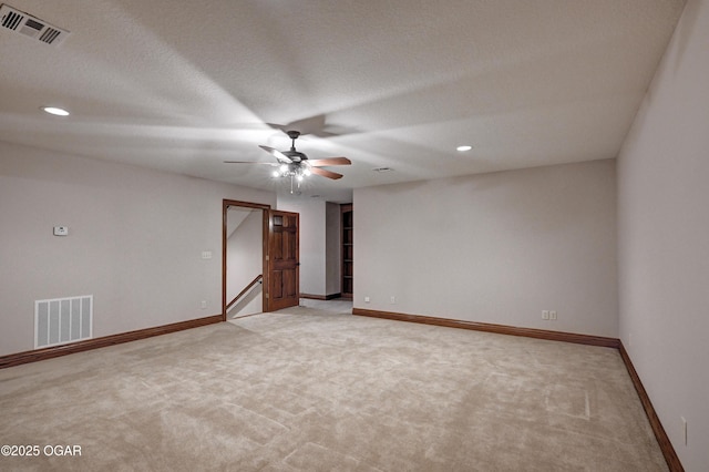 carpeted spare room with ceiling fan and a textured ceiling