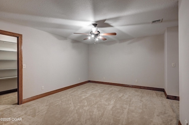 unfurnished room with ceiling fan, light colored carpet, and a textured ceiling