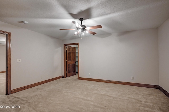 unfurnished room featuring light carpet, ceiling fan, and a textured ceiling