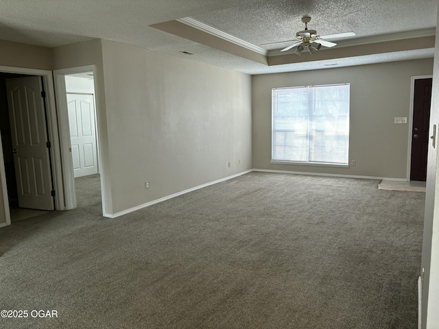 carpeted empty room featuring crown molding, ceiling fan, a textured ceiling, and a tray ceiling