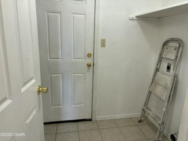 interior space with light tile patterned flooring and electric dryer hookup