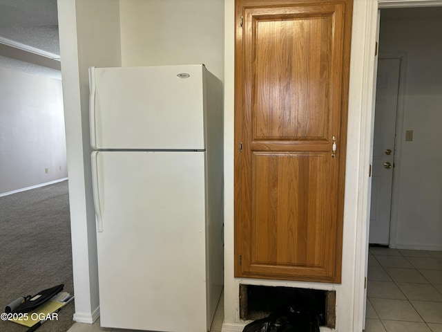 kitchen with light tile patterned flooring and white fridge