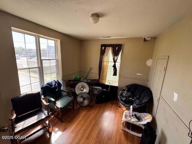 sitting room with wood finished floors and a healthy amount of sunlight